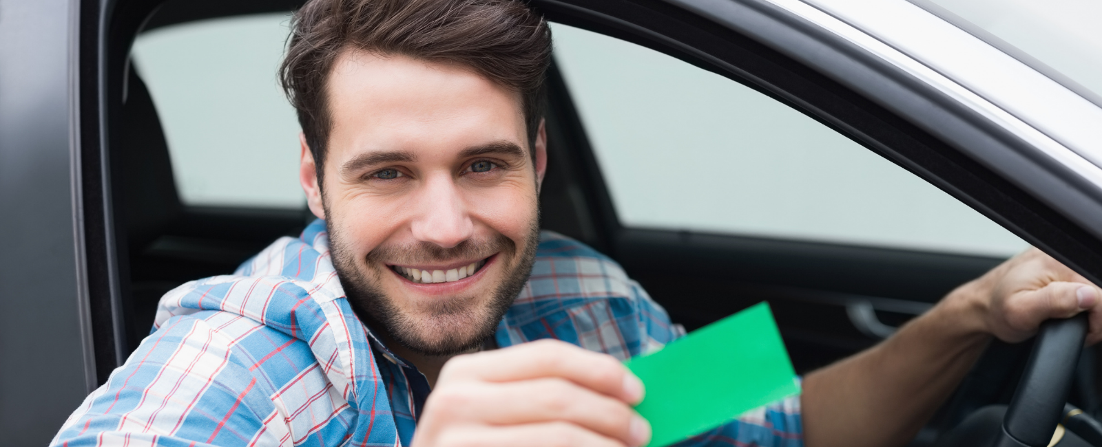 Photo of a man in a car showing his landfill card