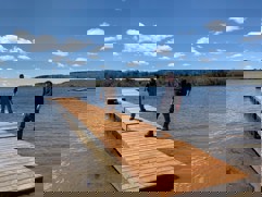 Two people standing on a new dock at Rotary Beach. The dock has a slight ramp to access other sections.